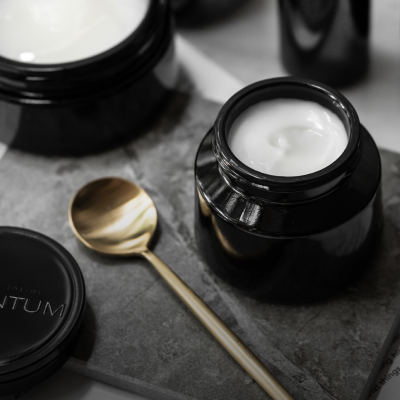 Argentum silver face cream on slate surface with gold spoon