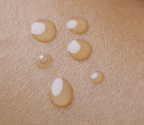 Droplets of natural face oil on skin
